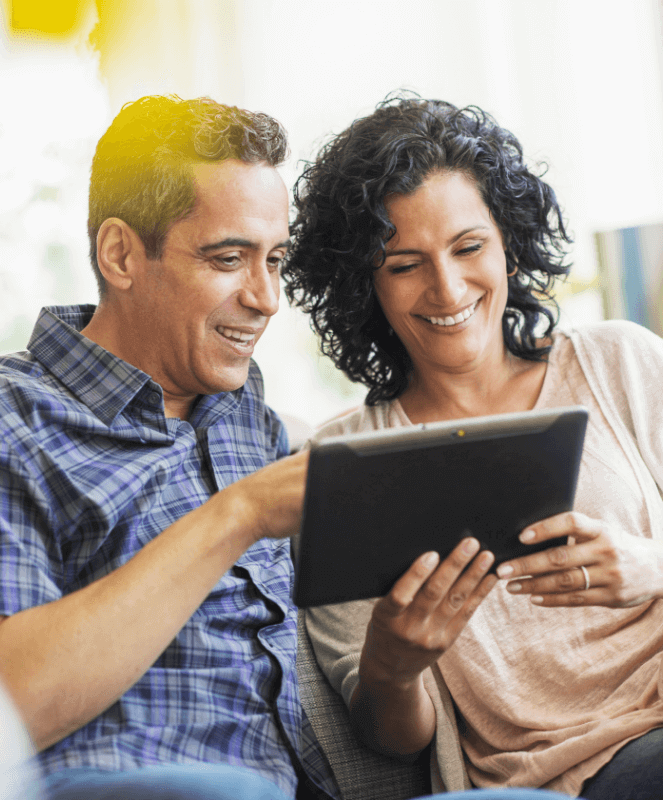 Couple smiling and looking at a tablet